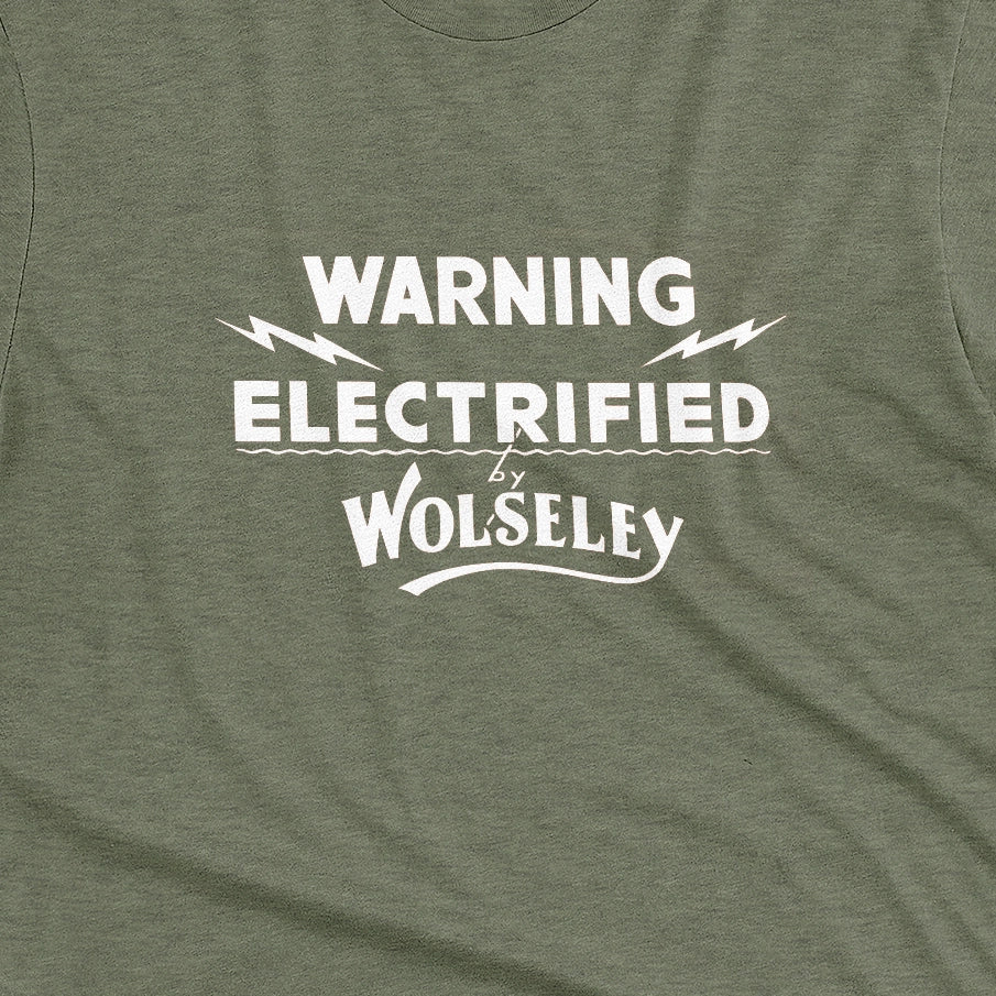 A green t-shirt with vintage graphics from an electric fence sign for the Wolseley brand from the early 1900s.