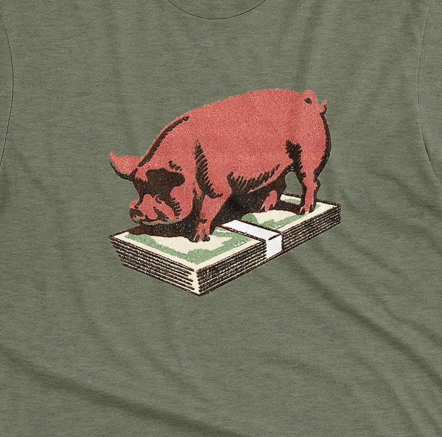 A green t-shirt featuring a retro graphic print of a pig standing on a stack of cash.