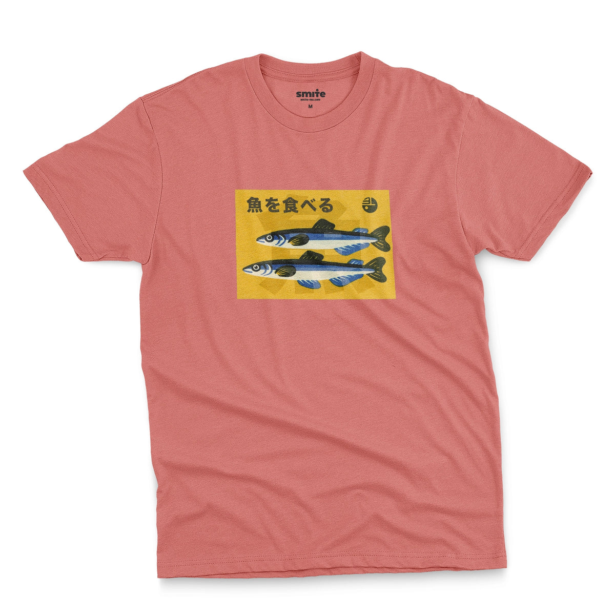 A coral pink t-shirt with a rectangular graphic print on the chest showing two blue and silver fish on a yellow background with the Japanese text 'Eat Fish'.