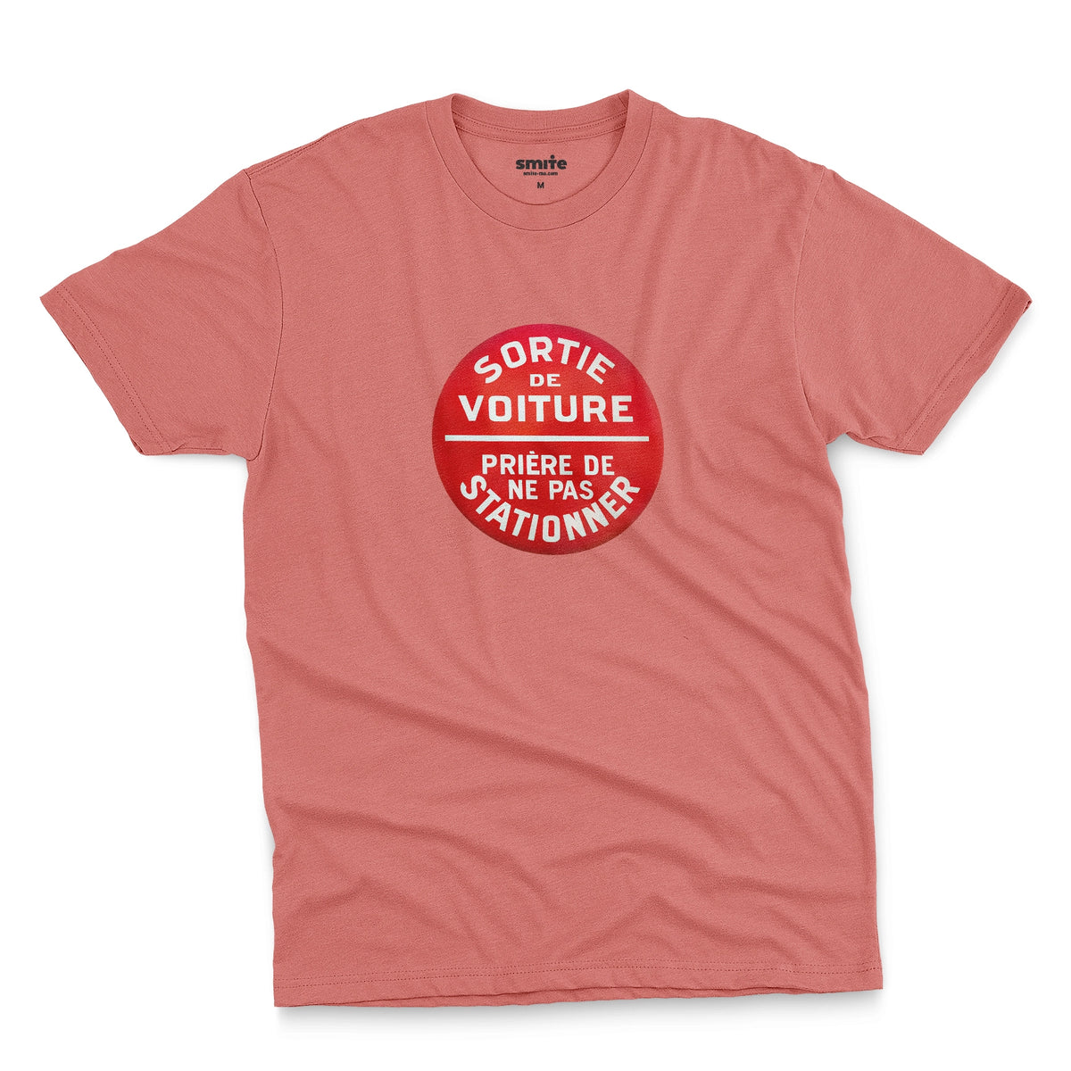 A coral pink t-shirt with a retro red and white graphic on the chest with French text 'SORTIE DE VOITURE PRIERE DE NE PAS STATIONNER'.