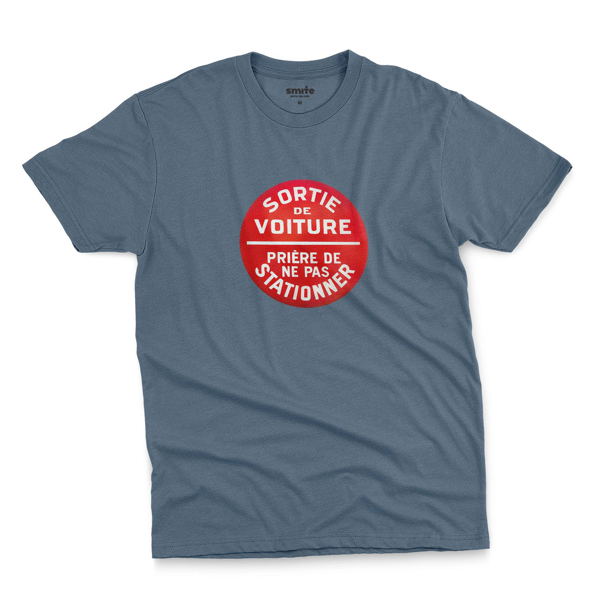 A blue t-shirt with a retro red and white graphic on the chest with French text 'SORTIE DE VOITURE PRIERE DE NE PAS STATIONNER'.
