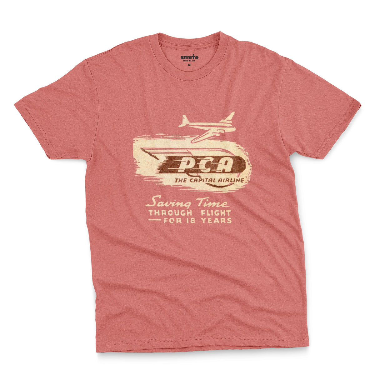 A coral pink t-shirt featuring a vintage graphic advertisement for 'PCA THE CAPITAL AIRLINE'.
