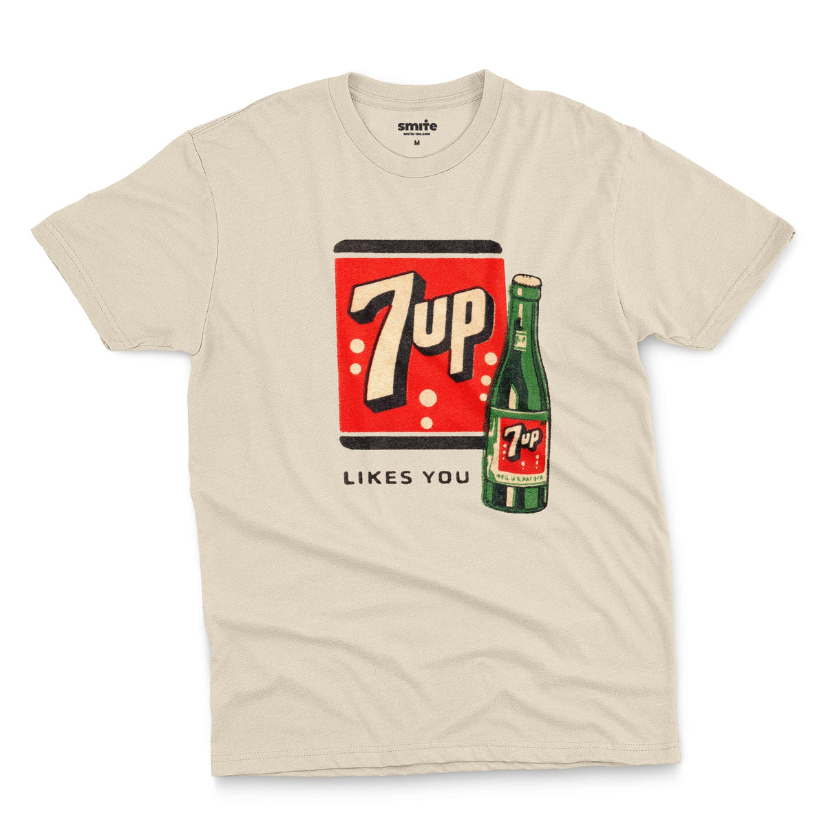 A beige t-shirt featuring a retro advertisement for 7up with the text '7up LIKES YOU'.
