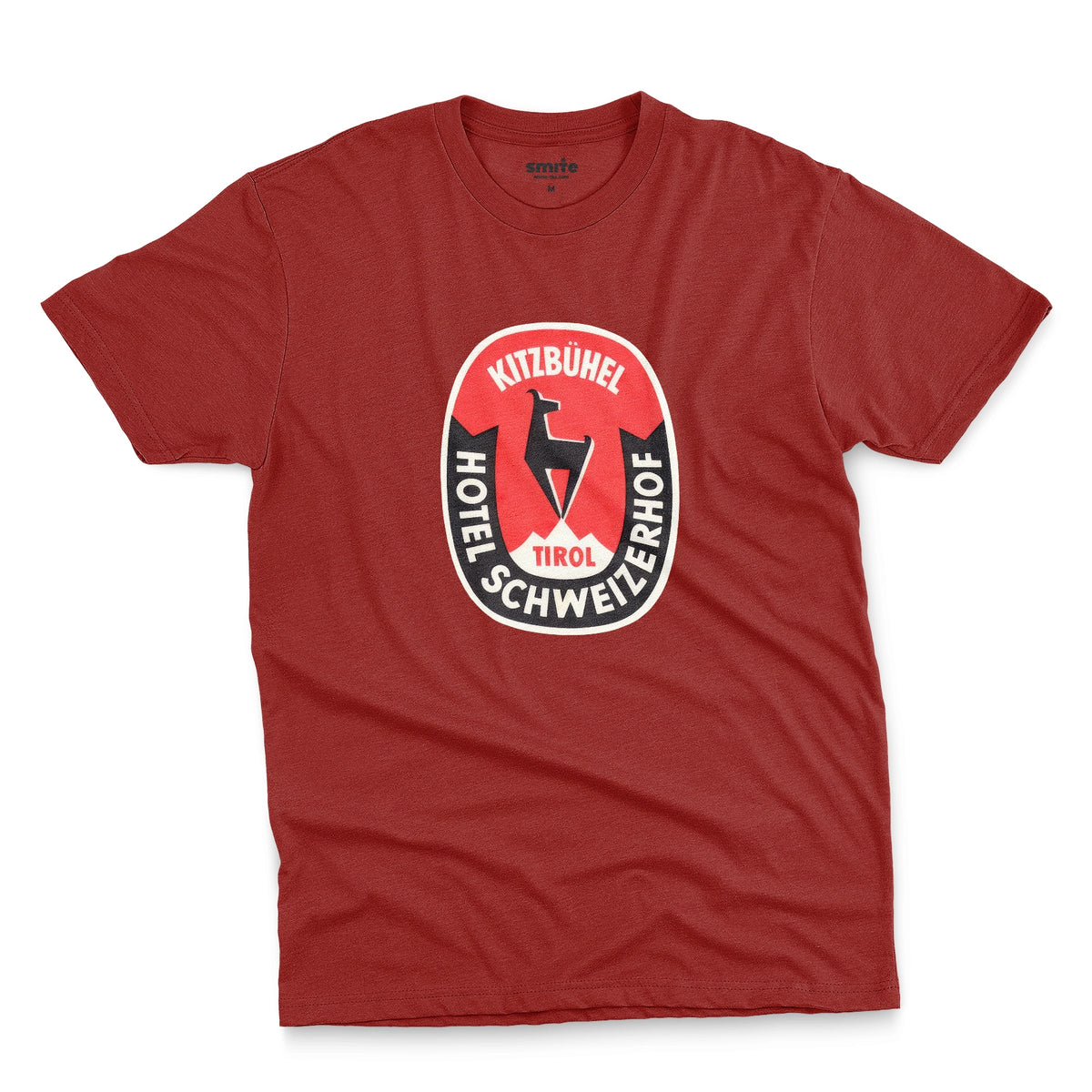 A red t-shirt featuring a retro baggage label for the Hotel Schweizerhof in the Austrian Alps.