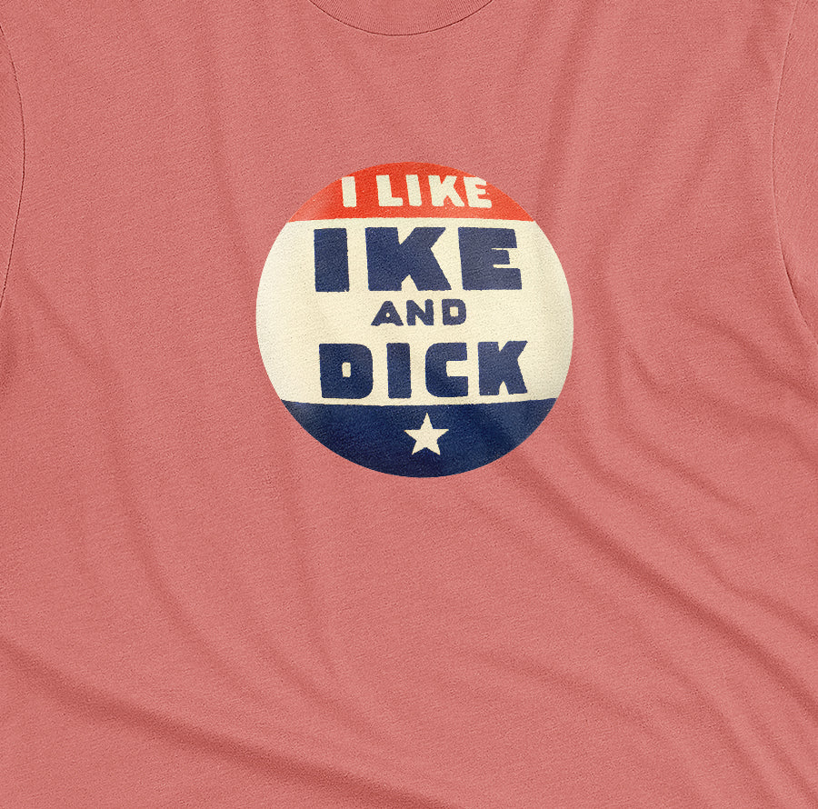 A coral pink t-shirt with  retro Eisenhower Nixon 1956 presidential campaign pin graphic.