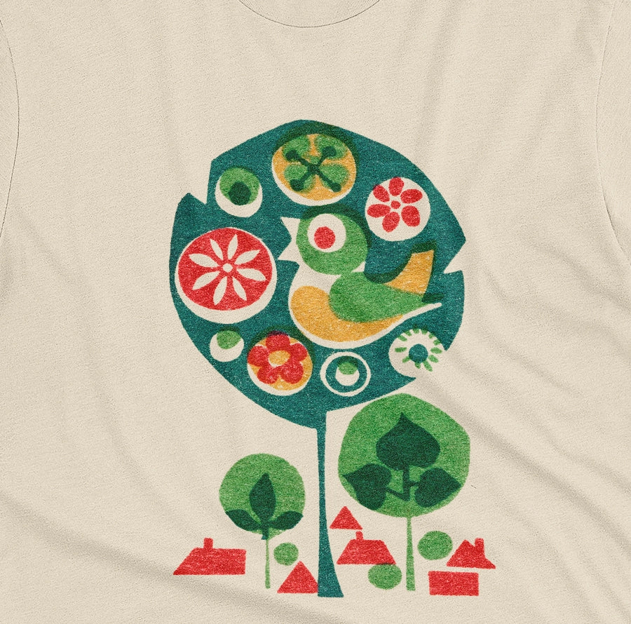 A beige t-shirt with a retro Czech illustration of a bird in a tree promoting happy work environments.