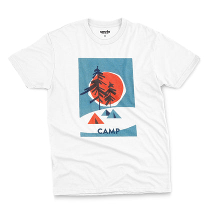 A white t-shirt featuring a 1960s retro-style graphic print of pine trees in front of a large orange-red sun within a blue square, with small orange and blue tents below and the word 'CAMP'.