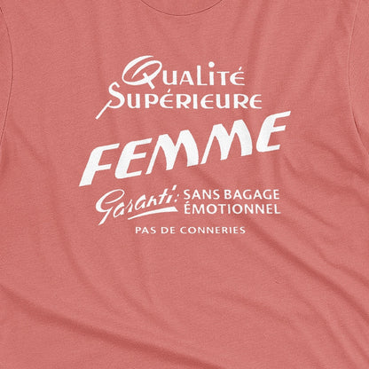 A coral pink t-shirt with white French text printed on the front. It translates as 'Superior Quality Woman Guarantee: No Emotional Baggage'.