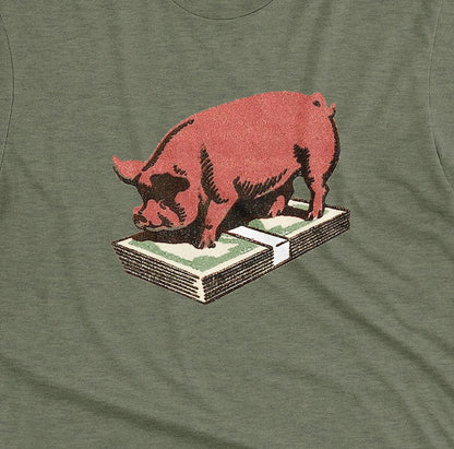 A green t-shirt featuring a retro graphic print of a pig standing on a stack of cash.