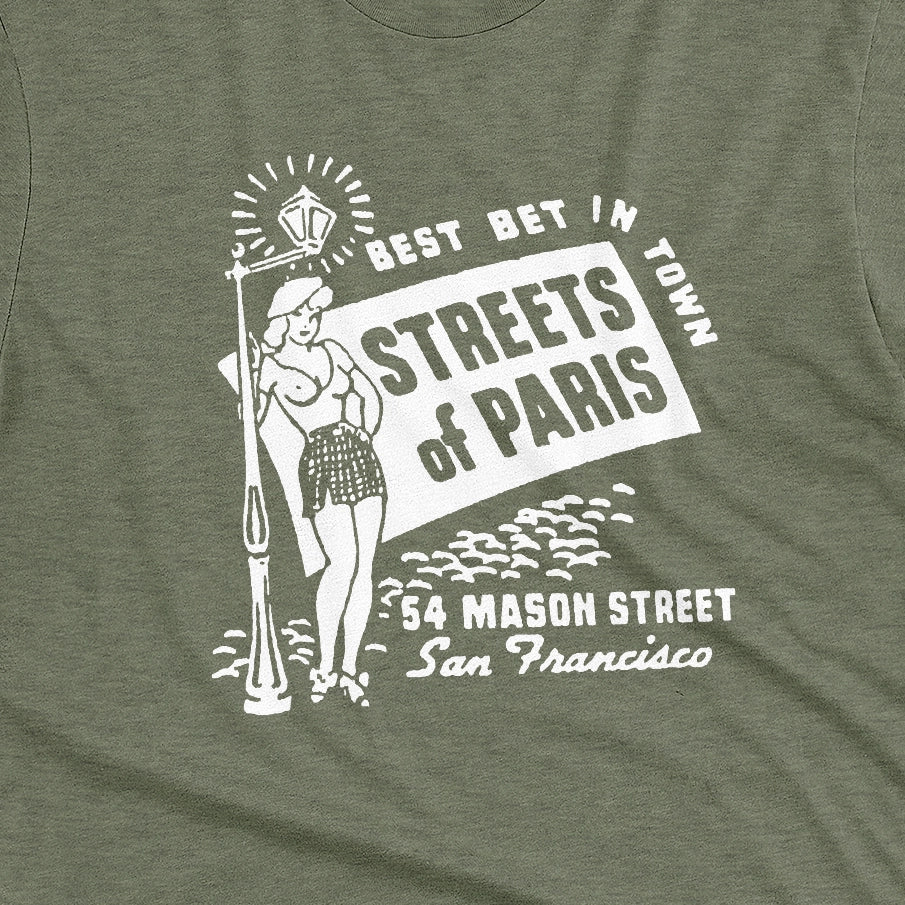 A green t-shirt with a vintage advertisement for 'STREETS OF PARIS', a bar in San Francisco.