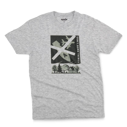 A grey marle t-shirt with a retro graphic print of an anti-war message featuring a cross, a plane, a house, and the text 'DON'T BOMB THINGS'.