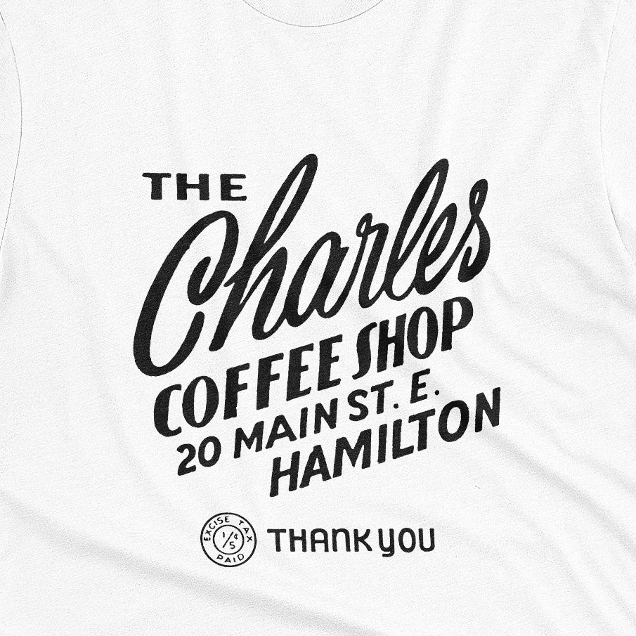 A white t-shirt with a retro typographic logo for The Charles Coffee Shop in Hamilton.
