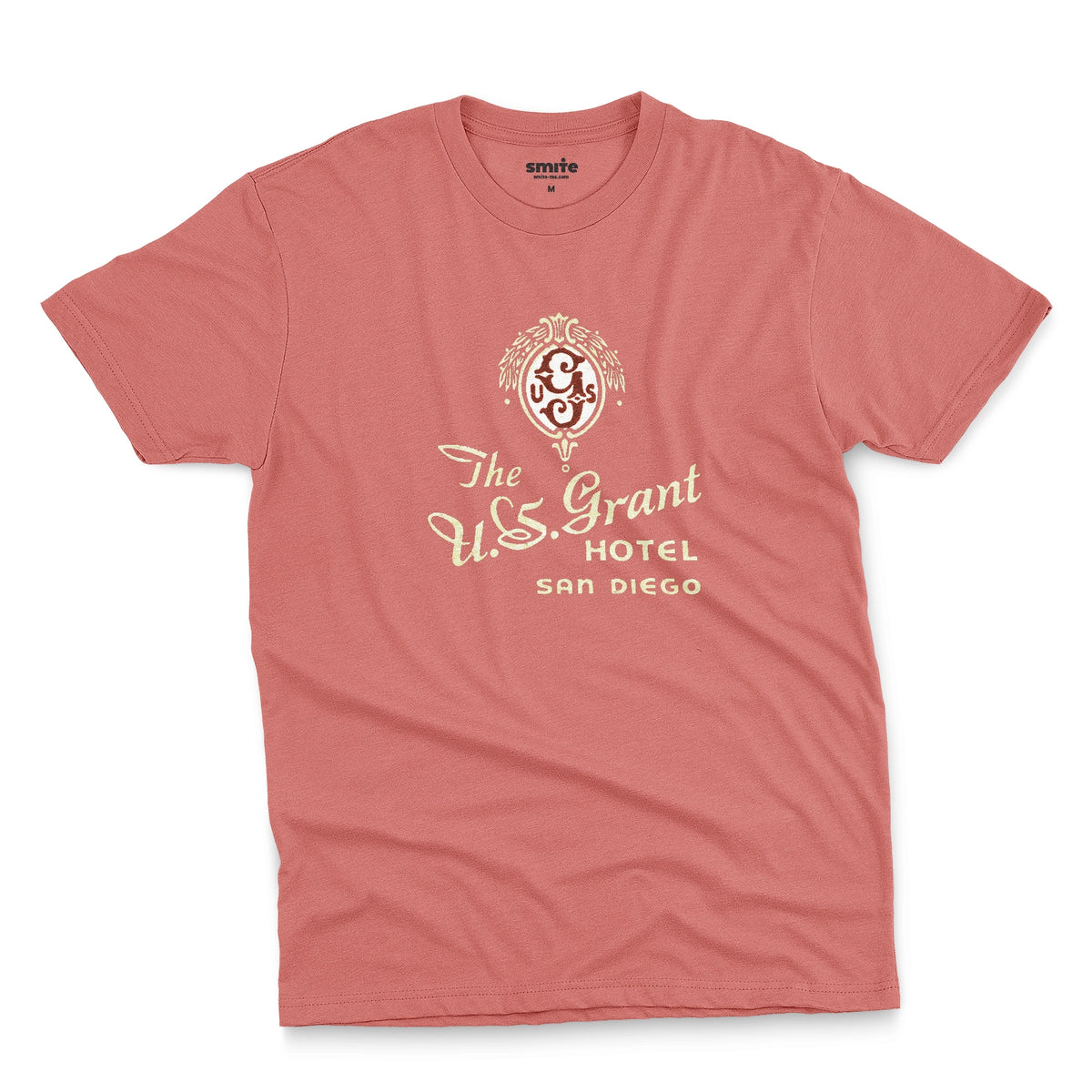 A coral pink t-shirt with a vintage logo for the U.S. Grant Hotel in San Diego.