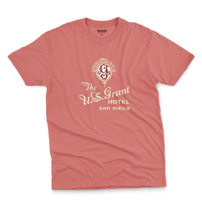 A coral pink t-shirt with a vintage logo for the U.S. Grant Hotel in San Diego.