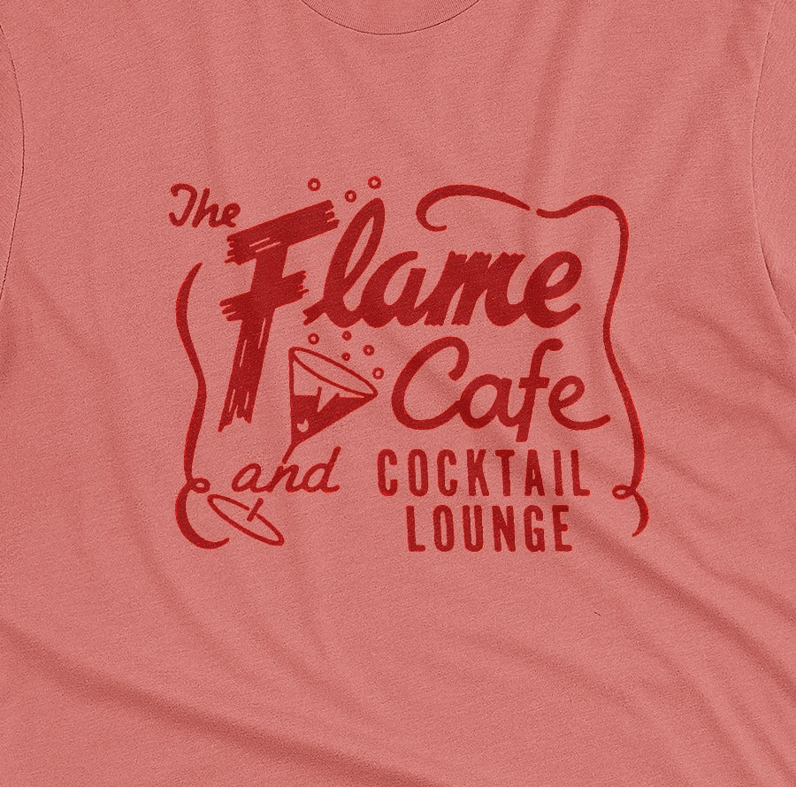 A coral pink t-shirt with an advertisement for 'The Flame Cafe and Cocktail Lounge' in Minneapolis.