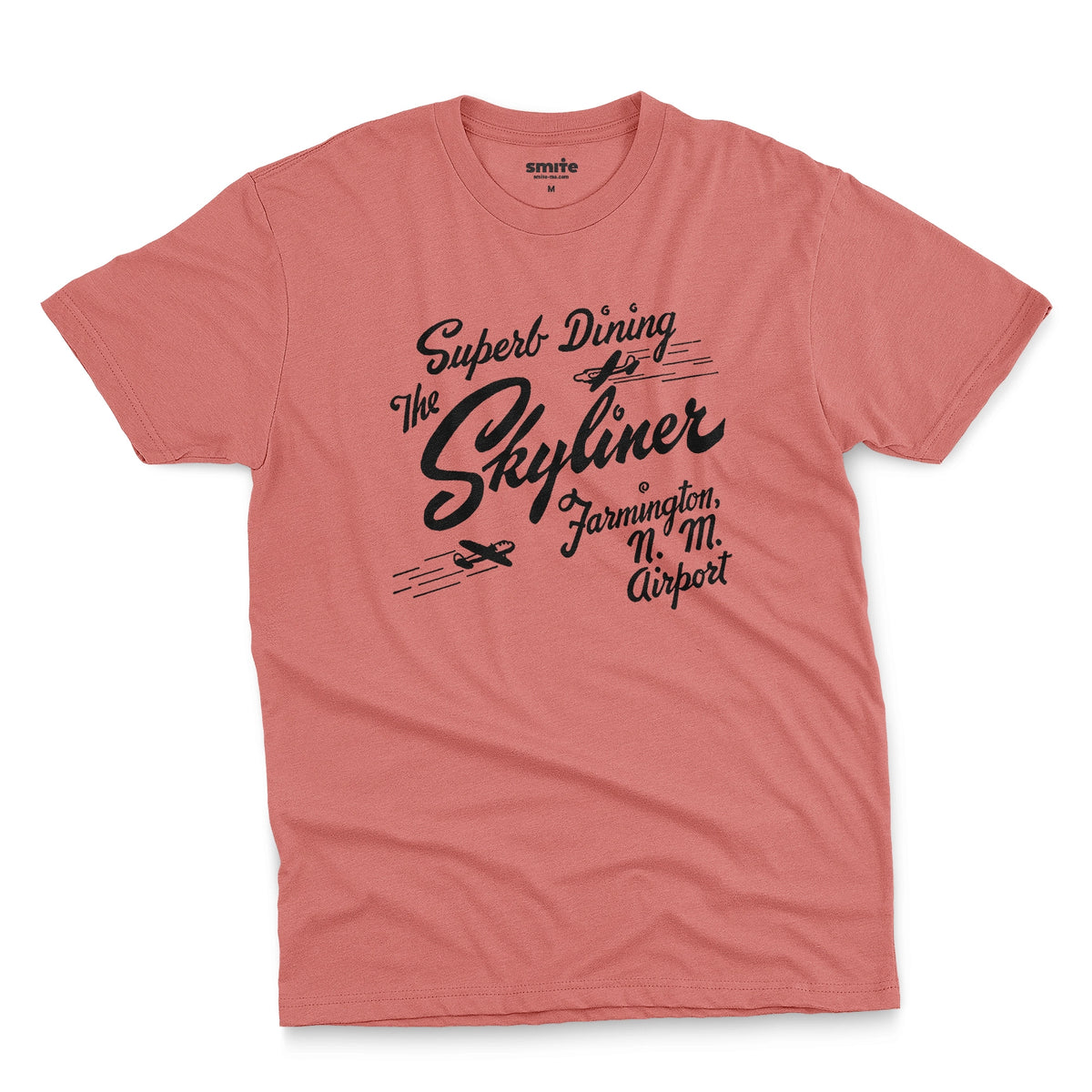 A coral pink t-shirt with a retro advertisement for The Skyliner restaurant at the airport in Farmington, New Mexico.