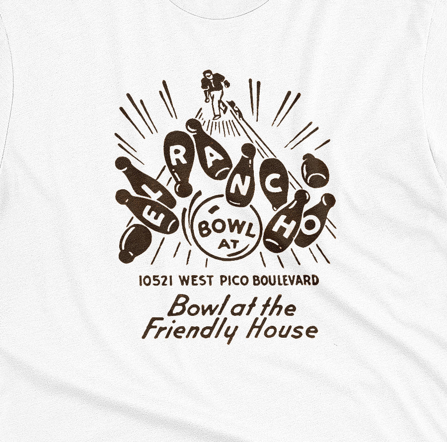 A white t-shirt with a retro 1960s graphic advertisement for El Rancho bowling alley features bowling pins, bowling balls, and the text 'Bowl at the Friendly House' along with an illustration of a bowler.