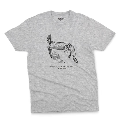 A grey marle t-shirt with a vintage engraved illustration of an arm holding a ferret and text saying: Correct way to hold a ferret.