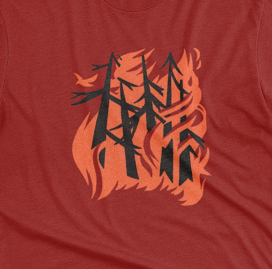 A red t-shirt with a retro graphic of stylized trees engulfed in orange flames and a single bird escaping.