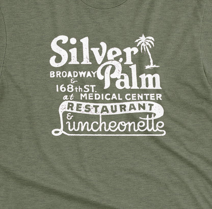 A green t-shirt with a retro advertisement for Silver Palm Restaurant in New York.
