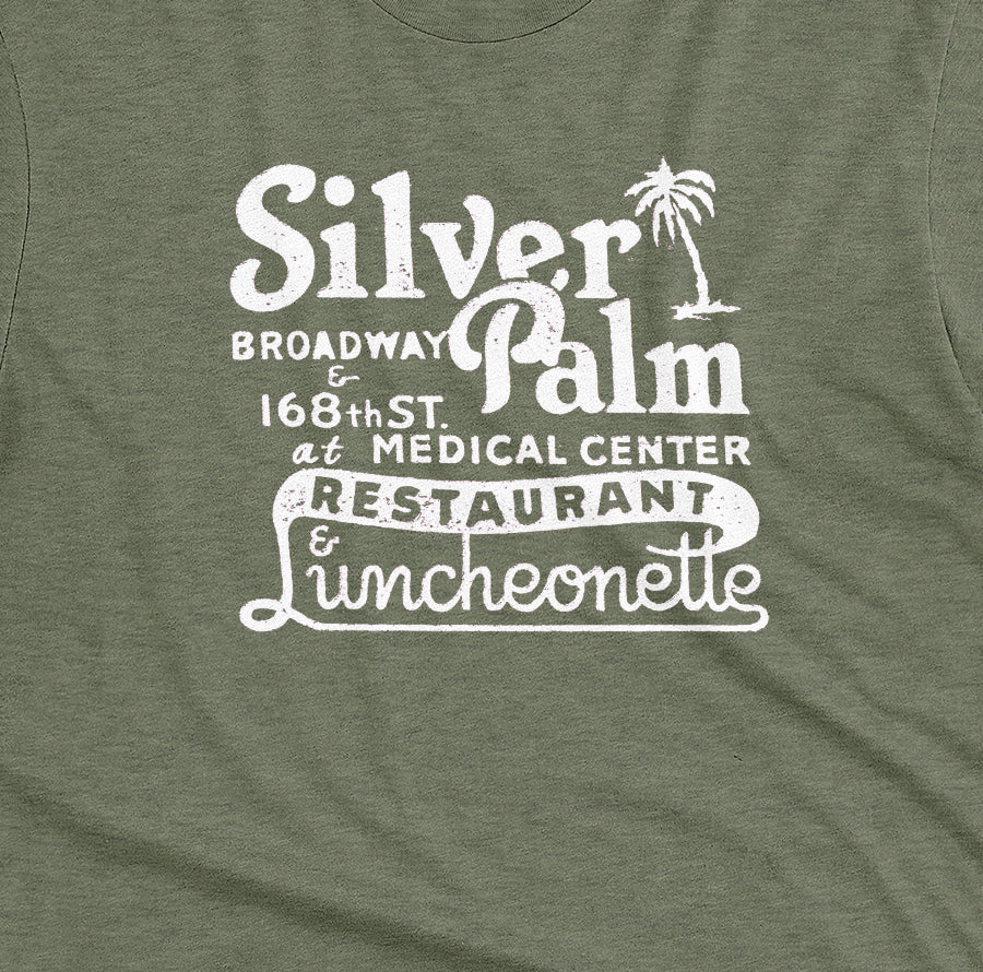 A green t-shirt with a retro advertisement for Silver Palm Restaurant in New York.
