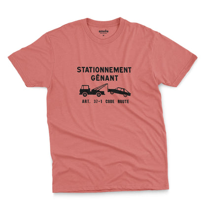 A coral pink t-shirt with a graphic print of a French street sign that says "nuisance parking" in French and a picture of a car being towed away.