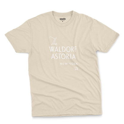 A beige t-shirt with a retro logo for The Waldorf Astoria hotel in New York.