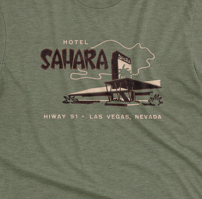 A green t-shirt with a vintage graphic advertising the 'Hotel Sahara' in Las Vegas, Nevada.
