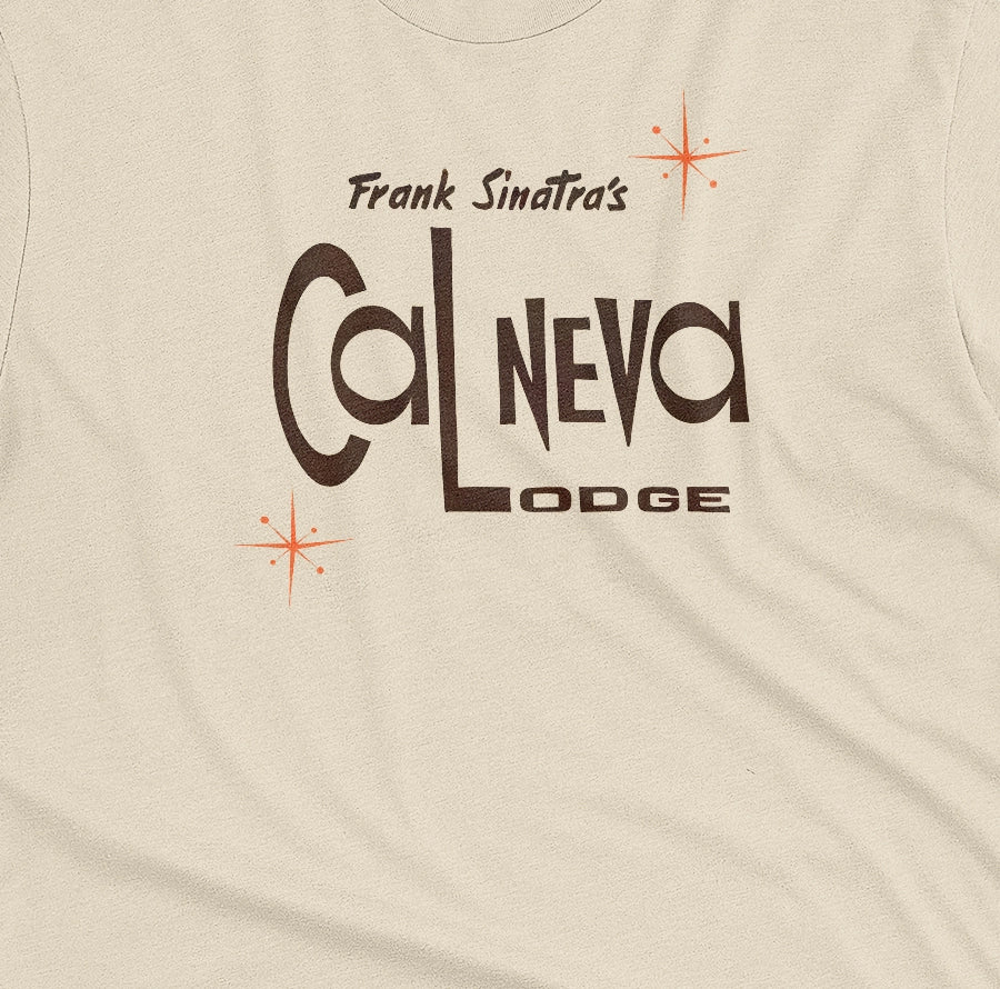 A beige t-shirt featuring a retro graphic print of 'Frank Sinatra's Cal Neva Lodge', the legendary hotel and casino.