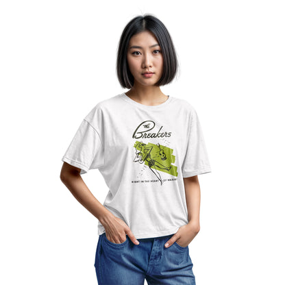 A white t-shirt featuring a retro illustration of a woman sunbathing, advertising The Breakers, a Hawaiian hotel.