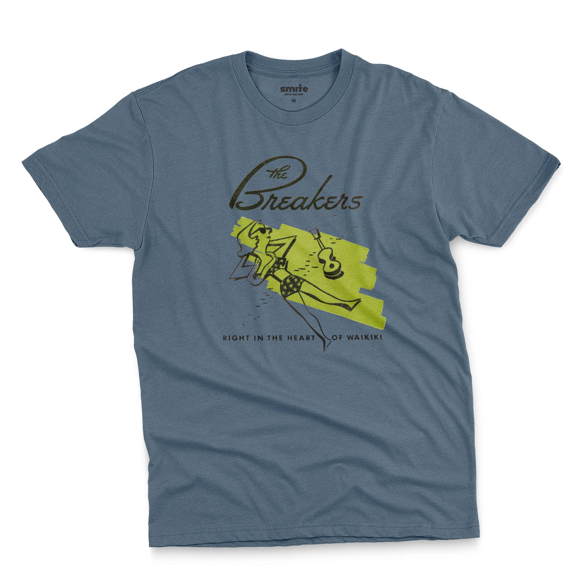 A blue t-shirt featuring a retro illustration of a woman sunbathing, advertising The Breakers, a Hawaiian hotel.
