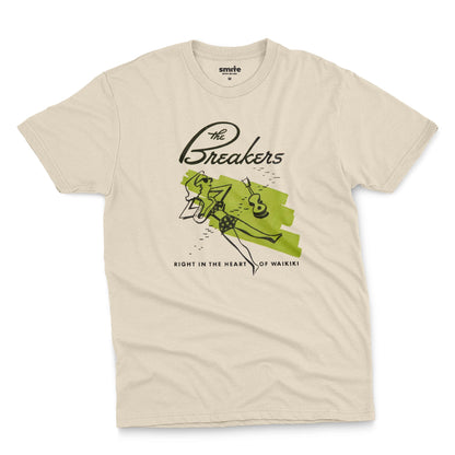 A beige t-shirt featuring a retro illustration of a woman sunbathing, advertising The Breakers, a Hawaiian hotel.