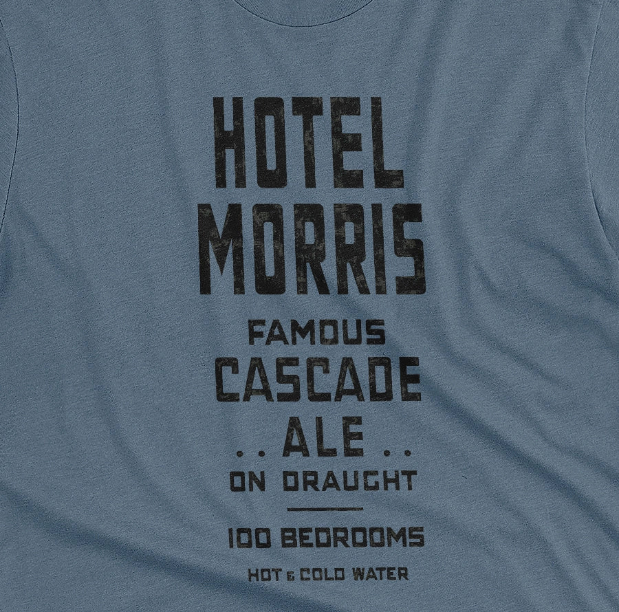 A blue t-shirt with a retro typographic advertisement for 'HOTEL MORRIS' from Sydney, Australia.