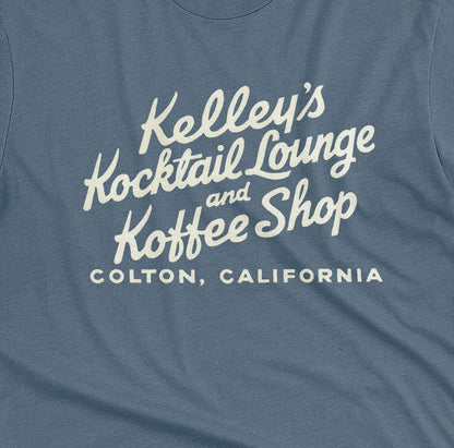 A blue t-shirt with a retro typographic advertisement for Kelley's Kocktail Lounge and Koffee Shop in Colton, California.