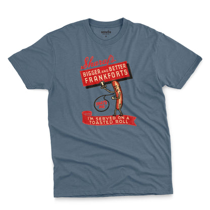 A blue t-shirt with a vintage graphic print of a hot dog character holding a sign that reads 'Sharaf's Bigger and Better Frankforts'.