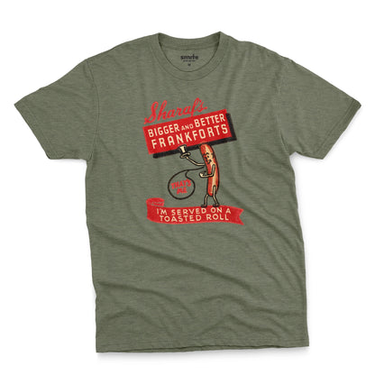 A green t-shirt with a vintage graphic print of a hot dog character holding a sign that reads 'Sharaf's Bigger and Better Frankforts'.
