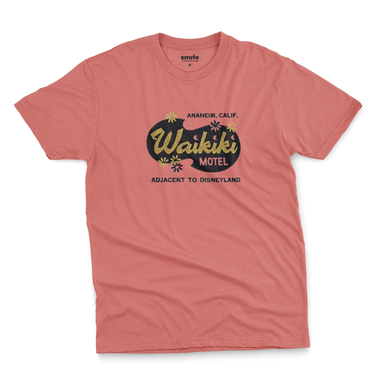 A coral pink t-shirt with a retro advertisement for the 'Waikiki Motel' in Anaheim, California.