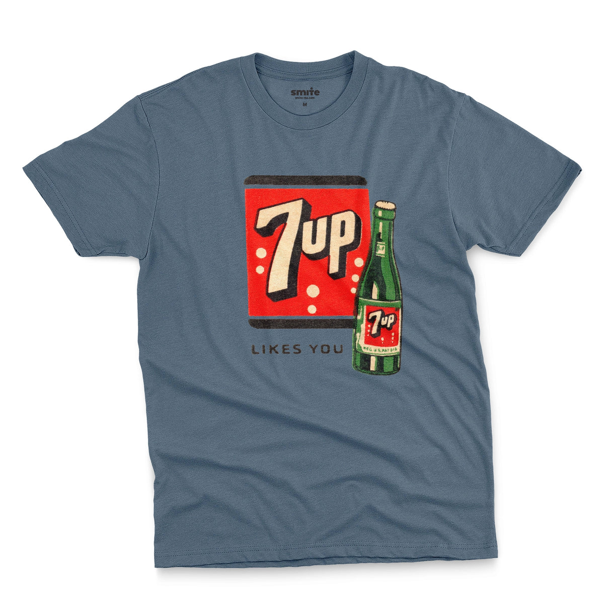 A blue t-shirt featuring a retro advertisement for 7up with the text '7up LIKES YOU'.