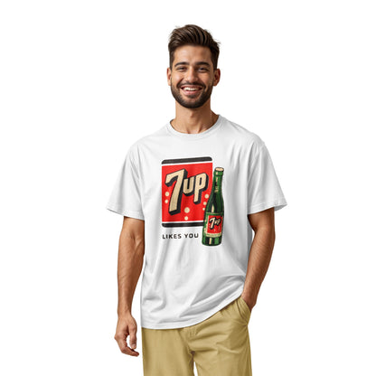 A white t-shirt featuring a retro advertisement for 7up with the text '7up LIKES YOU'.