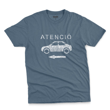 A blue t-shirt with a retro white stencil graphic of a car and the Spanish word 'ATENCIÓ'.