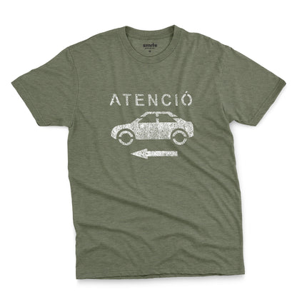 A green t-shirt with a retro white stencil graphic of a car and the Spanish word 'ATENCIÓ'.
