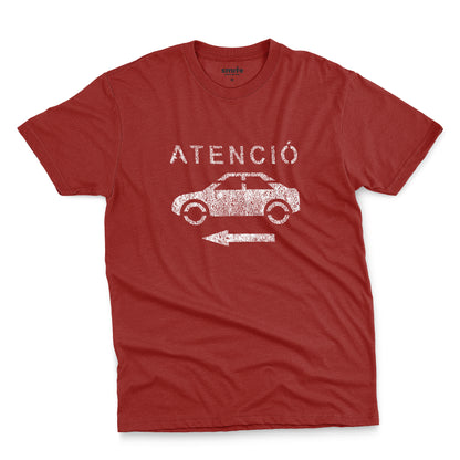 A red t-shirt with a retro white stencil graphic of a car and the Spanish word 'ATENCIÓ'.