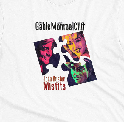 A white t-shirt featuring a colorful graphic advertisement for the movie The Misfits starring Clark Gable, Marilyn Monroe, and Montgomery Clift.