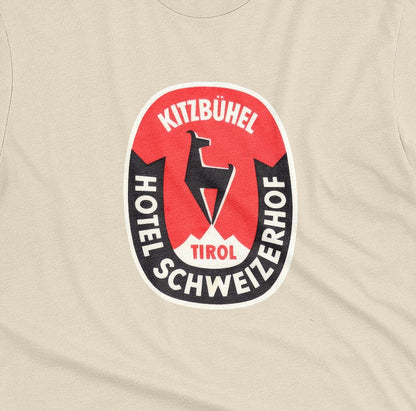 A beige t-shirt featuring a retro baggage label for the Hotel Schweizerhof in the Austrian Alps.