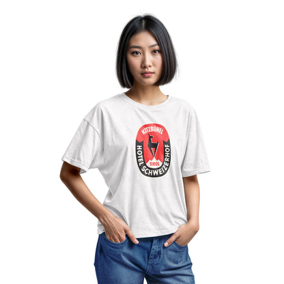 A white t-shirt featuring a retro baggage label for the Hotel Schweizerhof in the Austrian Alps.